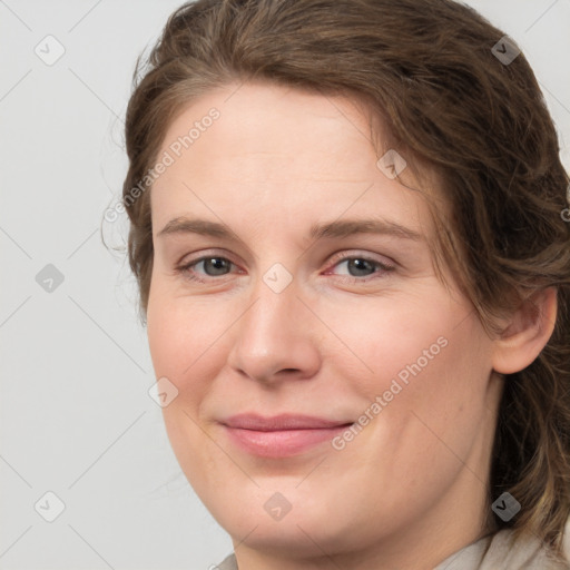 Joyful white young-adult female with medium  brown hair and grey eyes