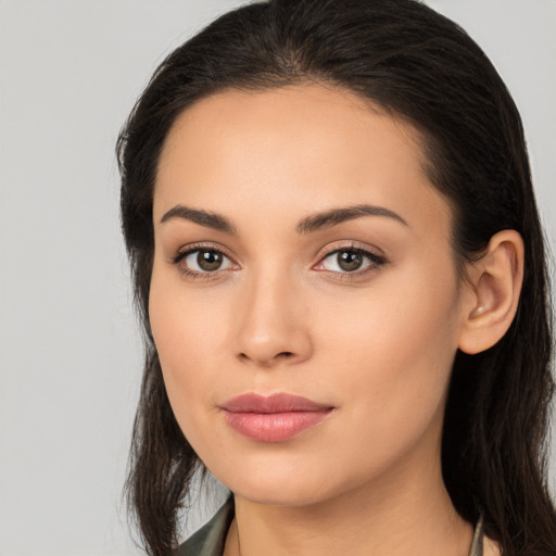 Joyful latino young-adult female with long  brown hair and brown eyes