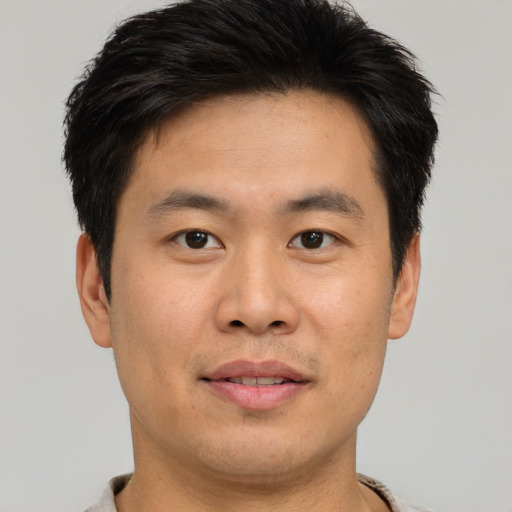 Joyful asian young-adult male with short  brown hair and brown eyes