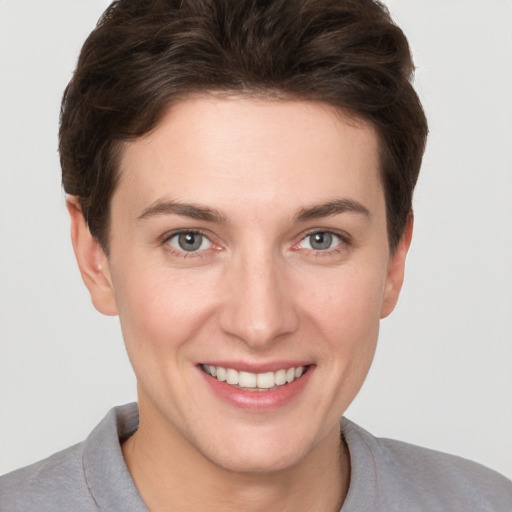 Joyful white young-adult female with short  brown hair and grey eyes