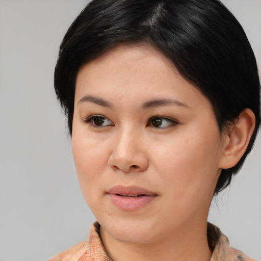 Joyful asian adult female with medium  brown hair and brown eyes