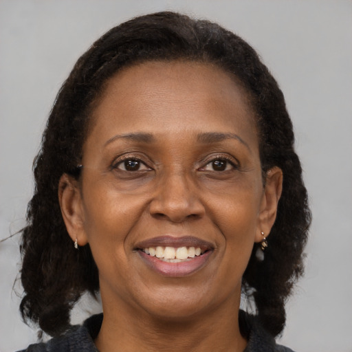 Joyful black adult female with medium  brown hair and brown eyes