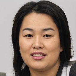 Joyful asian adult female with medium  brown hair and brown eyes