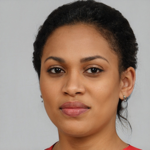 Joyful black young-adult female with long  brown hair and brown eyes