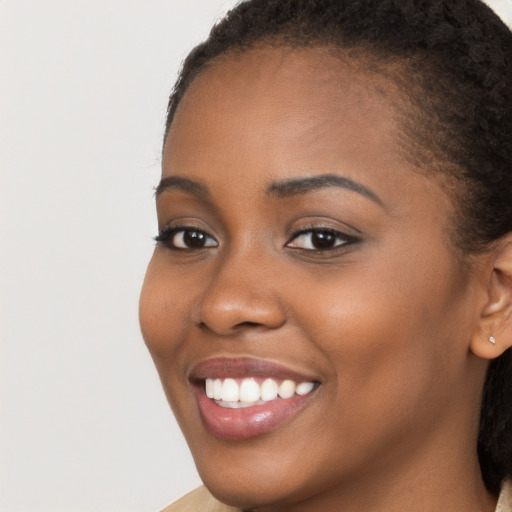 Joyful black young-adult female with long  brown hair and brown eyes