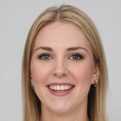 Joyful white young-adult female with long  brown hair and blue eyes