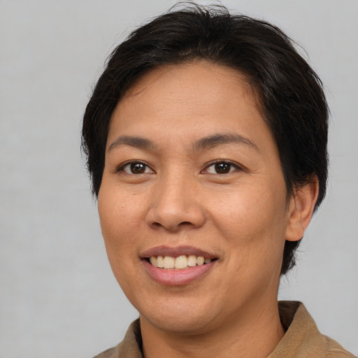 Joyful asian adult female with medium  brown hair and brown eyes