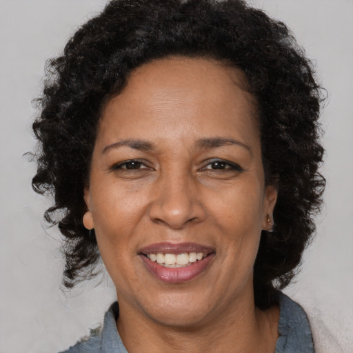 Joyful black adult female with short  brown hair and brown eyes