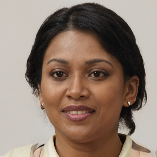 Joyful black adult female with medium  brown hair and brown eyes