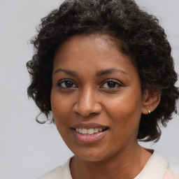 Joyful black young-adult female with medium  brown hair and brown eyes