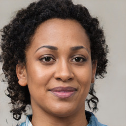 Joyful black adult female with medium  brown hair and brown eyes