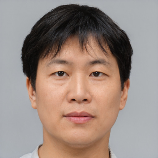 Joyful asian adult male with short  brown hair and brown eyes