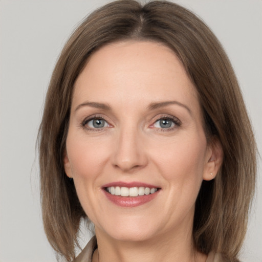 Joyful white adult female with medium  brown hair and grey eyes