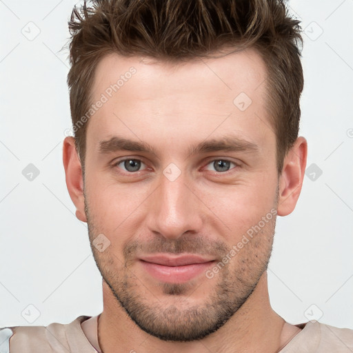 Joyful white young-adult male with short  brown hair and grey eyes