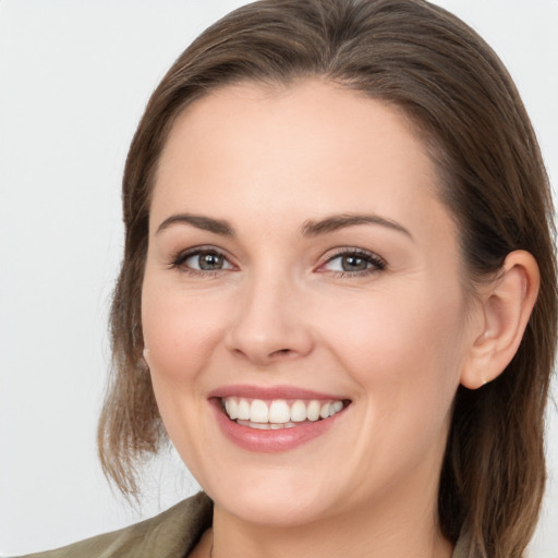 Joyful white young-adult female with medium  brown hair and grey eyes