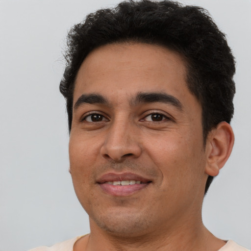 Joyful latino young-adult male with short  brown hair and brown eyes
