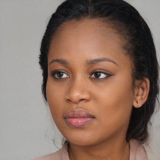 Joyful black young-adult female with long  brown hair and brown eyes