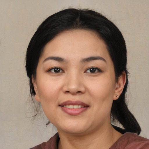 Joyful asian young-adult female with medium  black hair and brown eyes