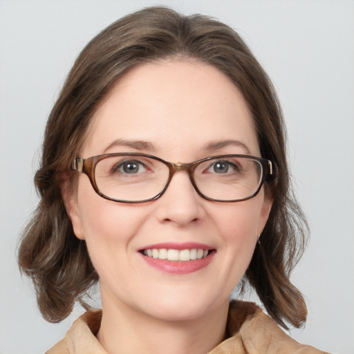 Joyful white young-adult female with medium  brown hair and blue eyes