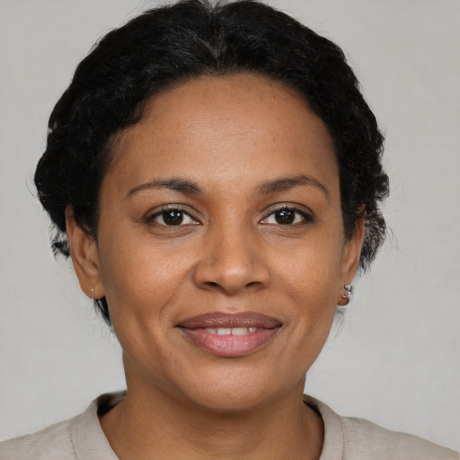 Joyful black adult female with short  brown hair and brown eyes