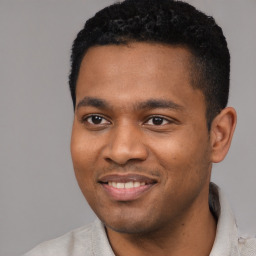 Joyful black young-adult male with short  black hair and brown eyes