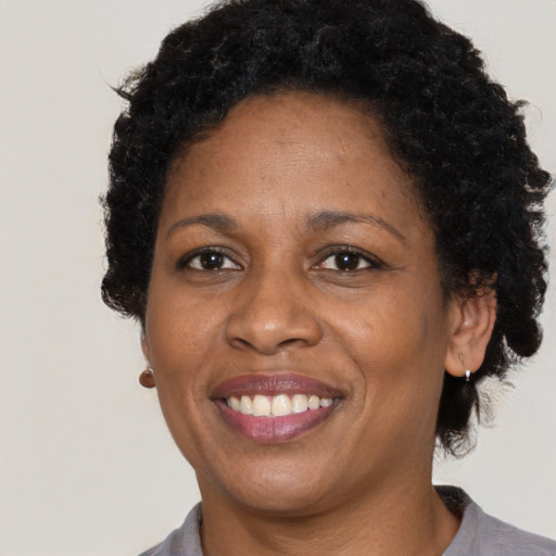 Joyful black adult female with short  brown hair and brown eyes