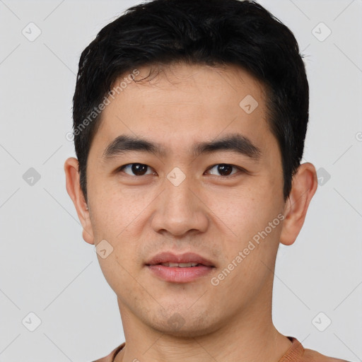 Joyful asian young-adult male with short  black hair and brown eyes