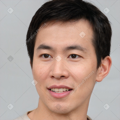 Joyful asian young-adult male with short  brown hair and brown eyes