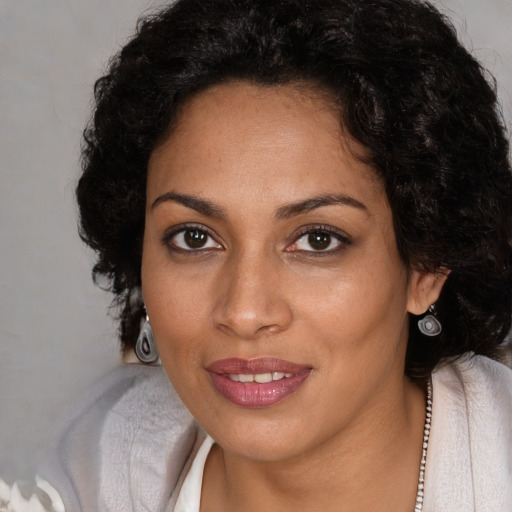 Joyful black young-adult female with long  brown hair and brown eyes
