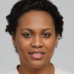 Joyful black young-adult female with short  brown hair and brown eyes