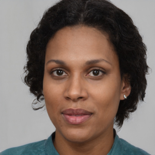 Joyful black adult female with short  brown hair and brown eyes
