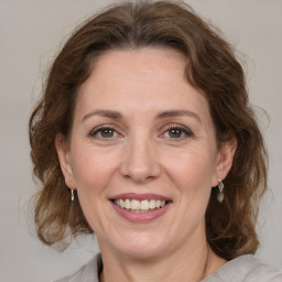 Joyful white adult female with medium  brown hair and green eyes