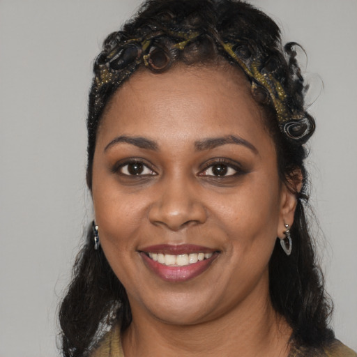 Joyful black young-adult female with long  brown hair and brown eyes