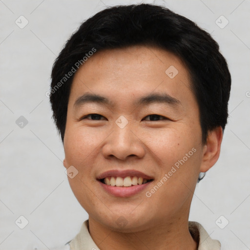 Joyful asian young-adult male with short  black hair and brown eyes