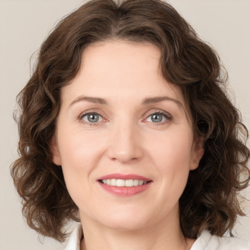 Joyful white young-adult female with medium  brown hair and green eyes