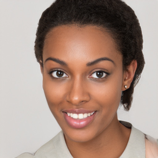 Joyful black young-adult female with long  brown hair and brown eyes