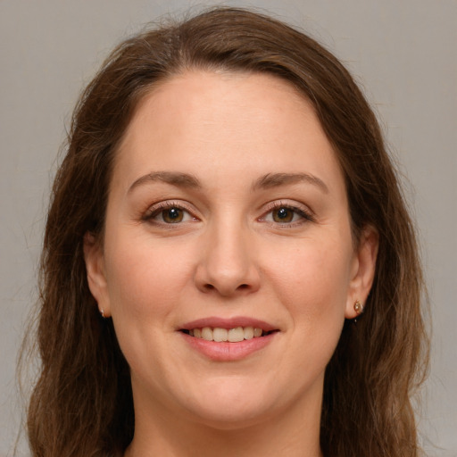 Joyful white adult female with long  brown hair and green eyes