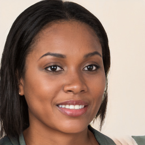 Joyful black young-adult female with long  brown hair and brown eyes