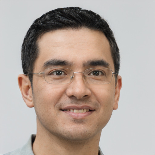 Joyful latino young-adult male with short  black hair and brown eyes