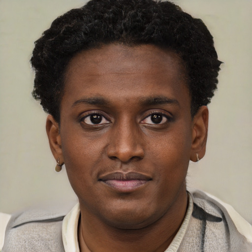 Joyful black young-adult male with short  brown hair and brown eyes