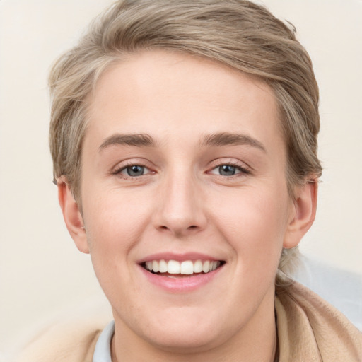 Joyful white young-adult female with short  brown hair and blue eyes