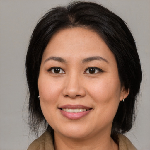 Joyful asian young-adult female with medium  brown hair and brown eyes