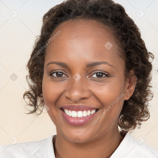 Joyful black young-adult female with long  brown hair and brown eyes