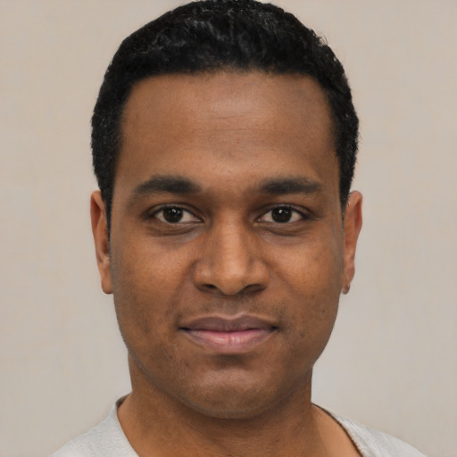 Joyful black young-adult male with short  black hair and brown eyes