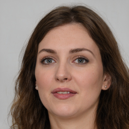 Joyful white young-adult female with long  brown hair and grey eyes