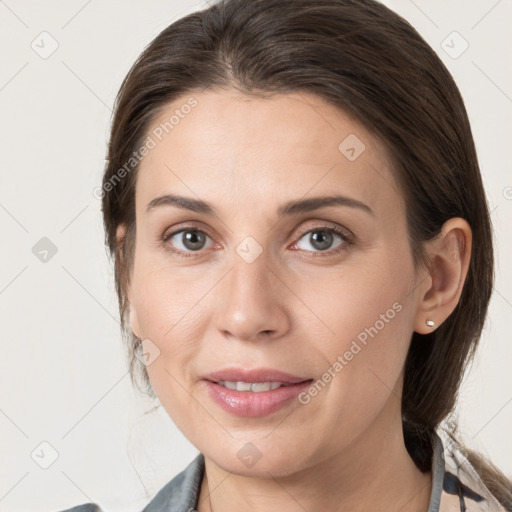 Joyful white young-adult female with medium  brown hair and grey eyes