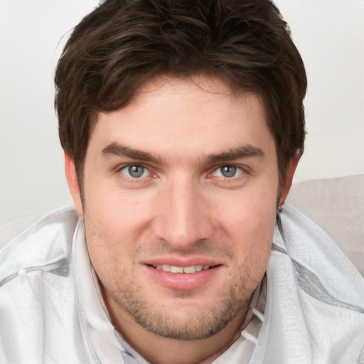 Joyful white young-adult male with short  brown hair and grey eyes