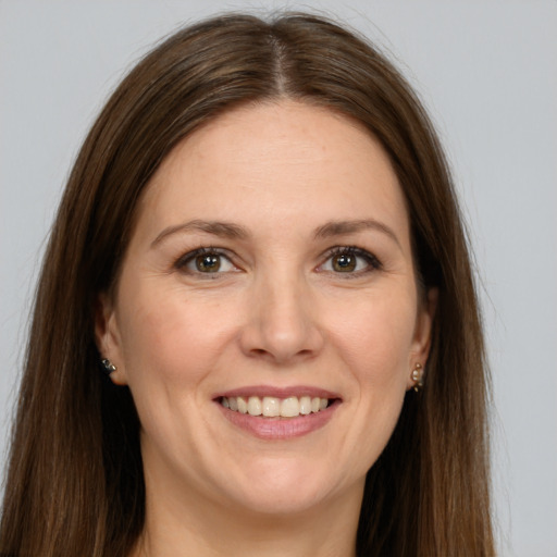 Joyful white adult female with long  brown hair and grey eyes