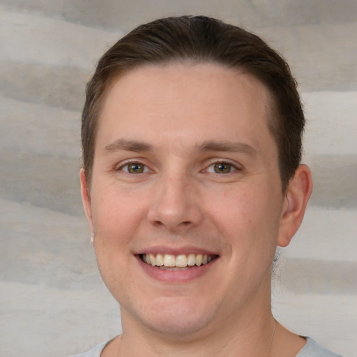 Joyful white young-adult male with short  brown hair and brown eyes