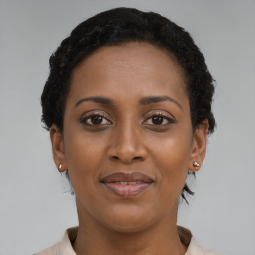 Joyful black young-adult female with short  brown hair and brown eyes